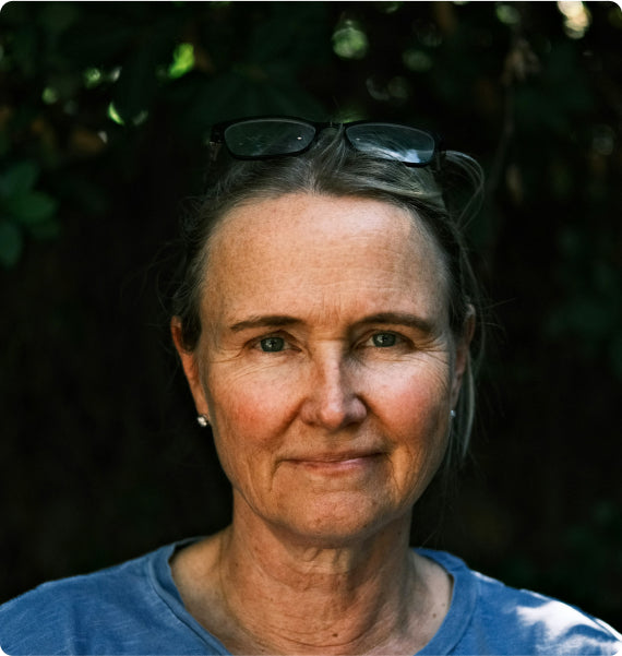 Woman with sunglasses on head against a dark background
